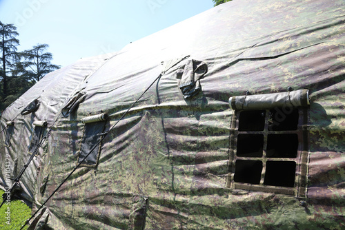 Military tents with green camouflage fabric in a training camp near the war zone photo