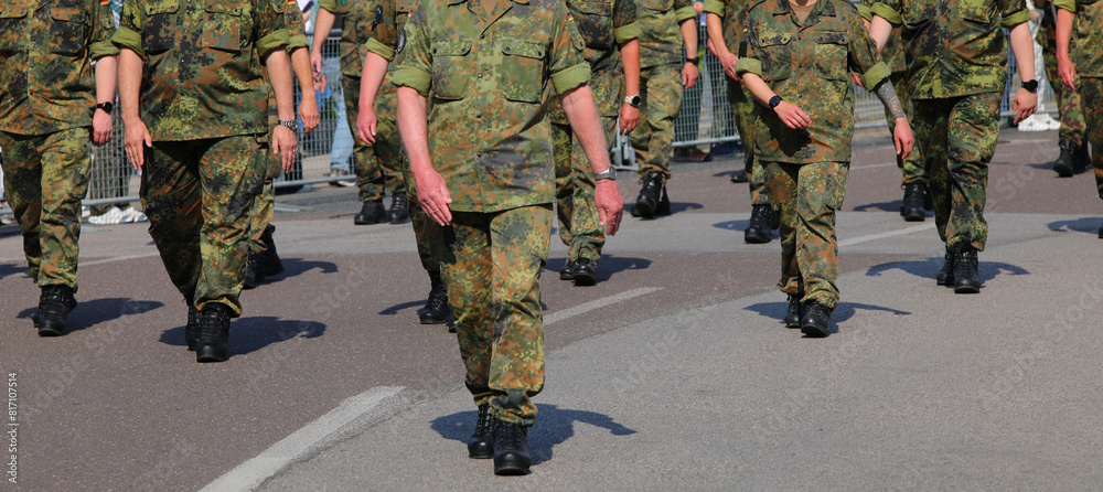 platoon of army soldiers marching down a city street in camouflage uniforms platoon of army soldiers marching down a city street in camouflage uniforms