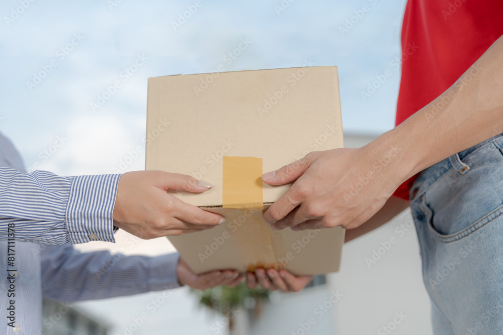 Courteous delivery guy handing over package to female customer Courteous delivery guy handing over package to female customer