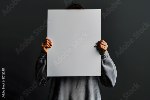 A detailed mockup of a blank poster held by a person on a solid dark gray background