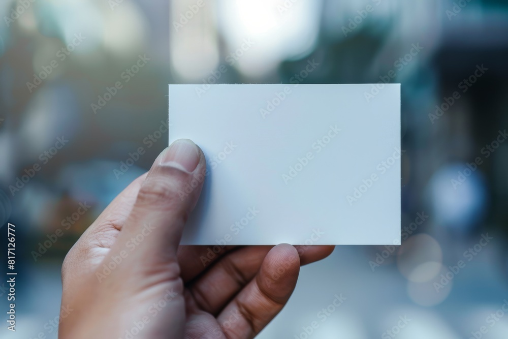 Close-up Hand Holding Blank Business Card on Blurred Background Close-up Hand Holding Blank Business Card on Blurred Background