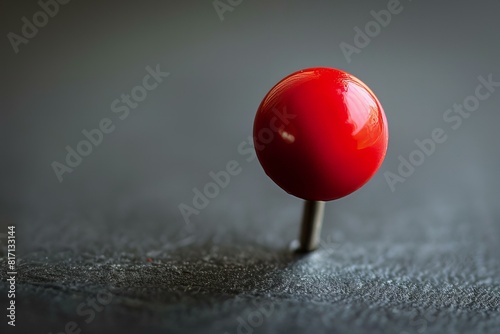 A red ball on a metal pin on a table