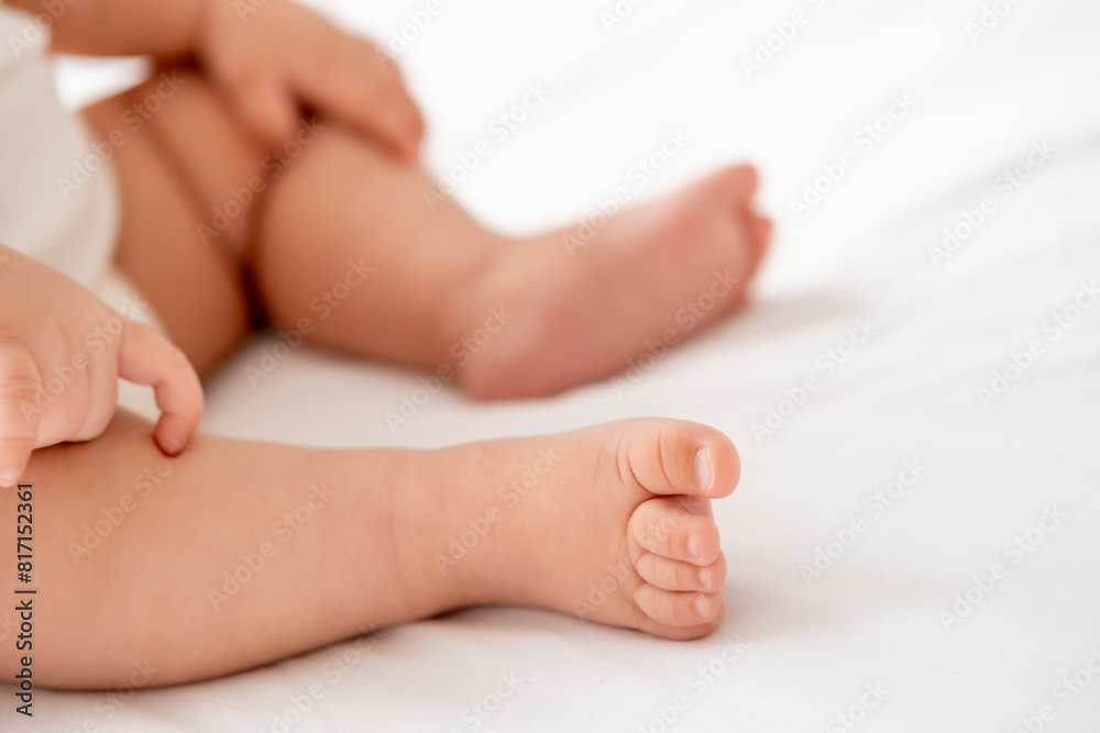 the legs of a small child on a white background on the bed, a pl