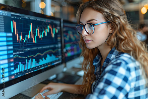 Young woman analyst working at computer with economic and financial graphs.