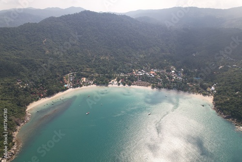 A drone shot of a sea nestled among towering mountains in a natural landscape, koh phangan island,Thailand