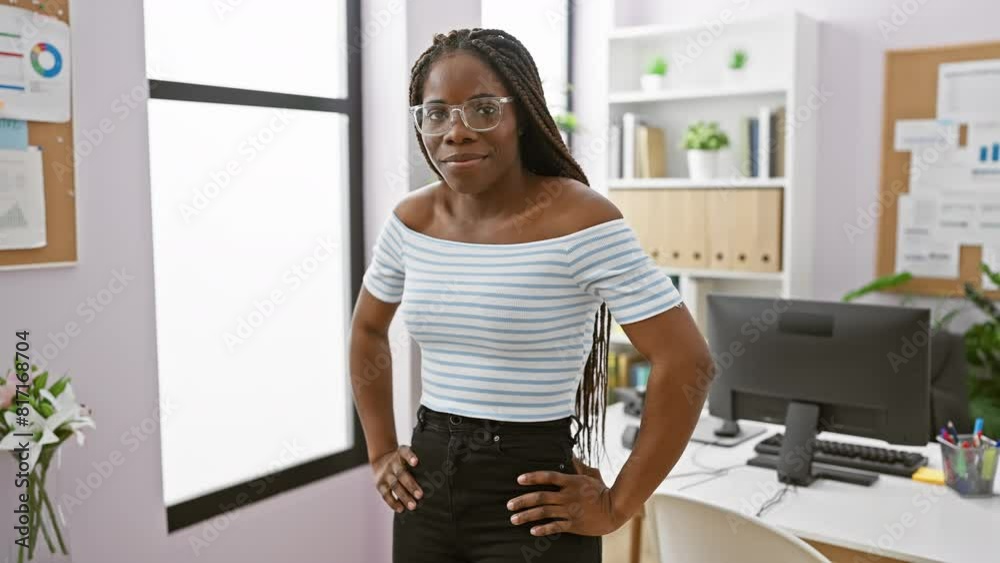 An african american woman with braids smiling in a modern office, conveying professionalism and confidence. An african american woman with braids smiling in a modern office, conveying professionalism and confidence.