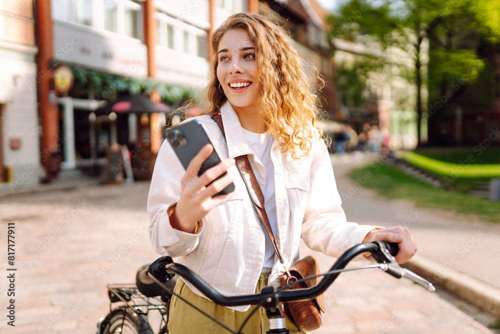 Obraz premium Bicycle, woman and phone in city feeling excited and happy about message while outdoor in summer with trendy look. Travel, weekend, relax and lifestyle concept. 