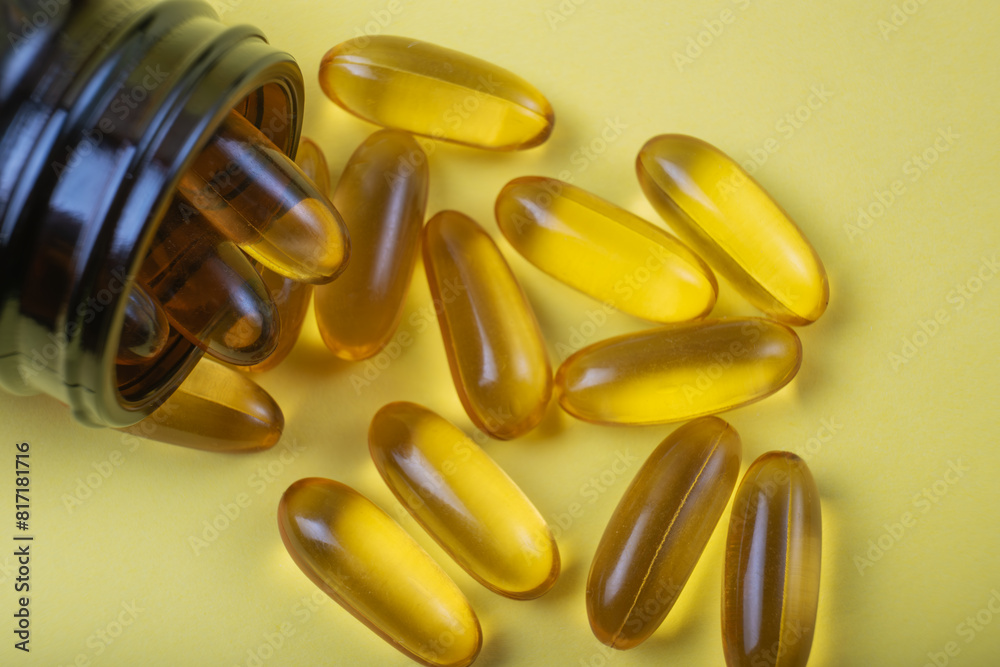 omega-3 capsules in a glass vial on a yellow background, a healthcare concept omega-3 capsules in a glass vial on a yellow background, a healthcare concept