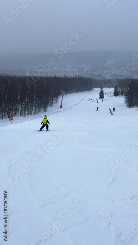 A chairlift at a ski resort on a cloudy winter day in the Ural Mountains. A lift on the background of factory pipes. Climbing the mountain. Gubakha, Perm Krai, 4K photo