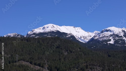 Parallax shot of mountain top emerging from behind a ridgeline in the foreground