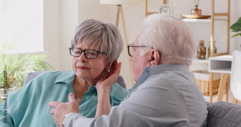Senior people talking at home, woman having hearing loss problems, chatting with old man sitting on sofa, family couple, grandmother having trouble following conversation, feeling frustrated 