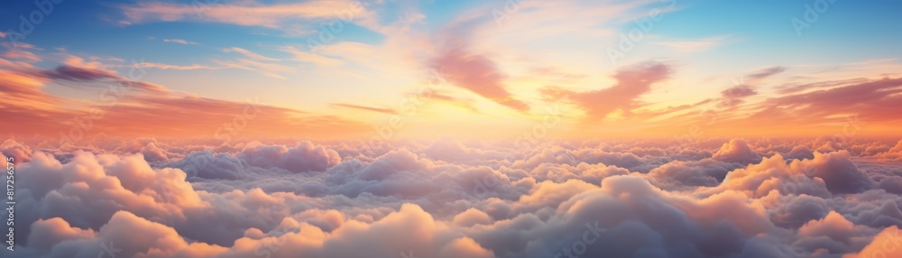 A dramatic cloudscape at sunrise with pink and golden glowing clouds against a clear blue sky