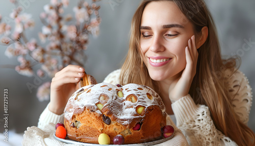 Woman with delicious Italian Easter dove cake near grey wall, closeup