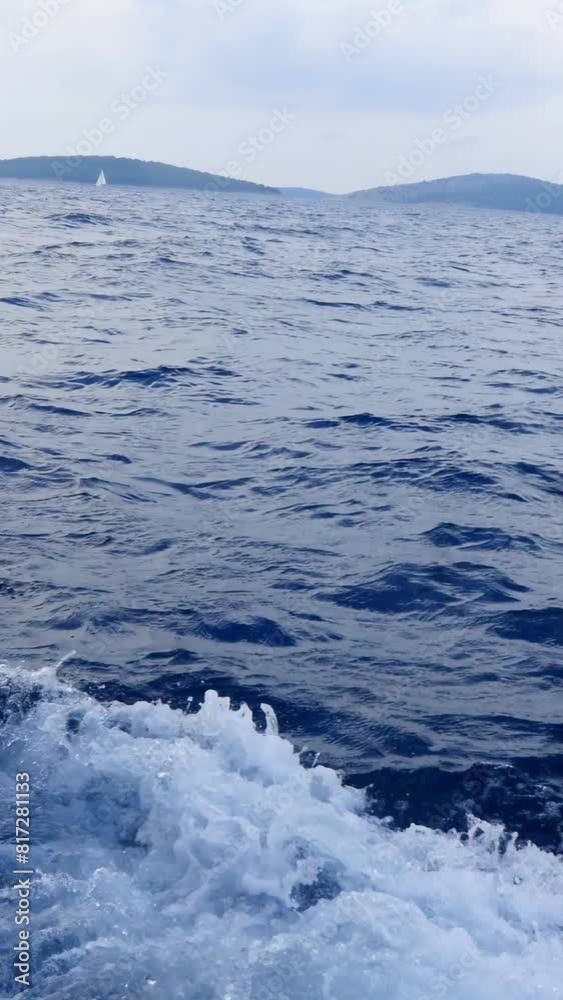 A calm ocean with a boat in the distance. The water is blue and the sky is cloudy A calm ocean with a boat in the distance. The water is blue and the sky is cloudy
