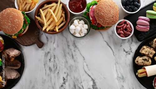 junk food double border over a white marble banner background assortment of take out and fast foods pizza hamburgers french fries chips hot dogs sweets overhead view with copy space