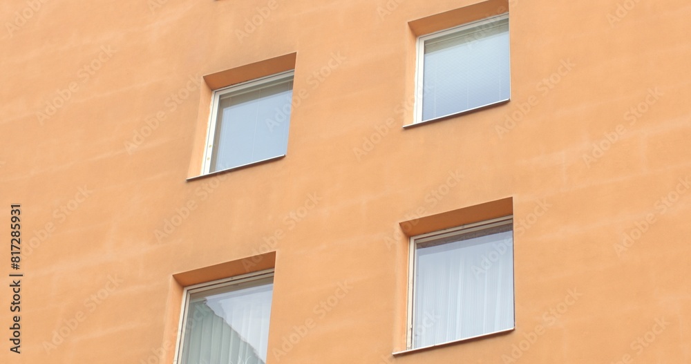 City living. Orange facade of a multi-story residential panel building. Witness the architectural symmetry and vibrant community life. Modern urban landscape. City living. Orange facade of a multi-story residential panel building. Witness the architectural symmetry and vibrant community life. Modern urban landscape.