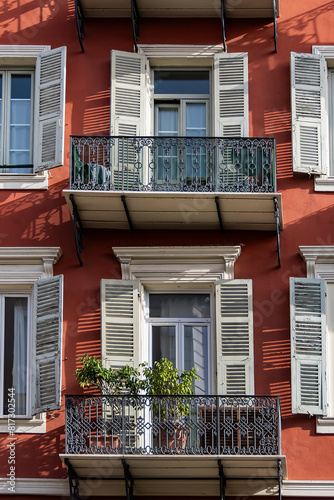 Architectural fragments of the facades of ancient houses in Nice: beautiful windows, balconies, shutters. Nice, capital of the Alpes-Maritimes department on the French Riviera.