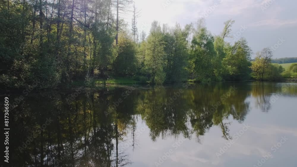 Lake and green forest trees. Forest reflection in the water. Magical atmosphere. Lake and green forest trees. Forest reflection in the water. Magical atmosphere.