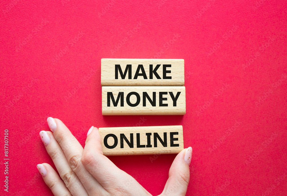 Make Money Online symbol. Concept words Make Money Online on wooden blocks. Businessman hand. Beautiful red background. Business and Make Money Online concept. Copy space. Make Money Online symbol. Concept words Make Money Online on wooden blocks. Businessman hand. Beautiful red background. Business and Make Money Online concept. Copy space.