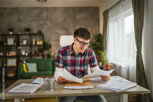 Young caucasian man with eyeglasses sit and study for exam at home