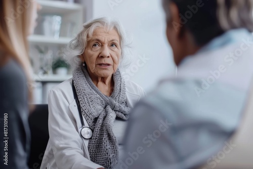 Elderly woman engaged in a serious consultation with a medical professional in a health care setting photo
