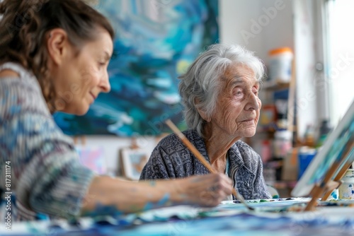 A focused elderly woman enjoys painting on canvas in a bright, colorful art studio