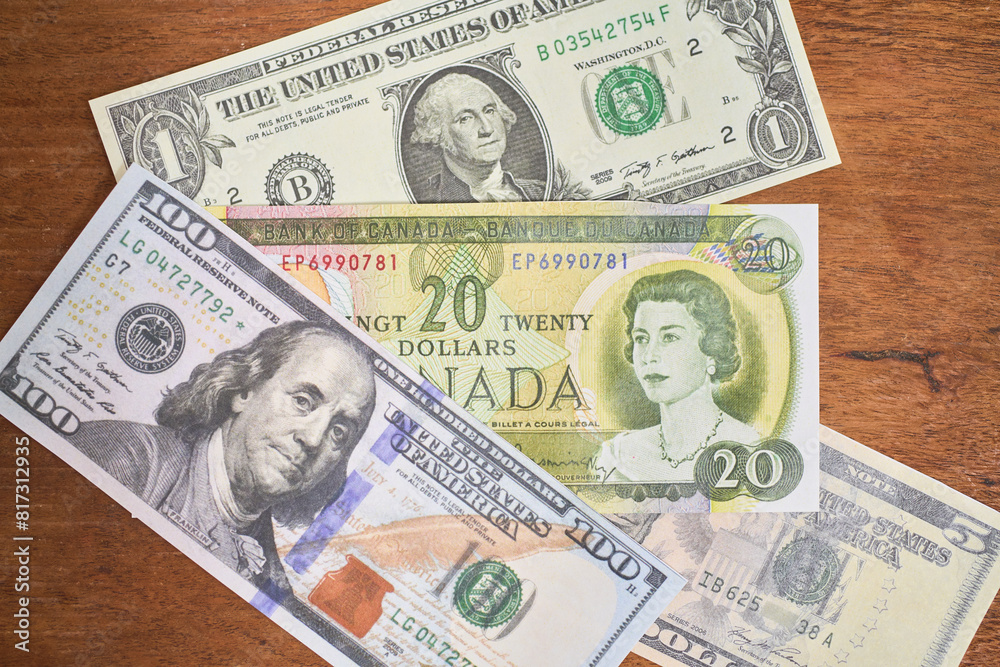 Comparison of dollar bill with canadian dollar, concept of inflation or abundance Comparison of dollar bill with canadian dollar, concept of inflation or abundance