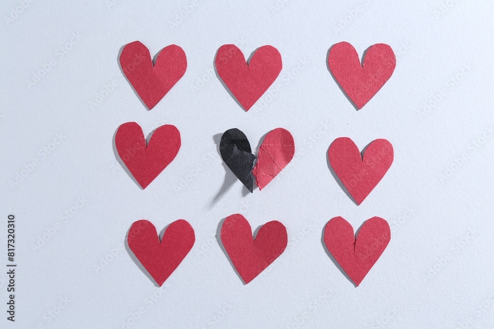 Halves of torn paper heart and red decorative hearts on gray background, flat lay. Breakup concept Halves of torn paper heart and red decorative hearts on gray background, flat lay. Breakup concept