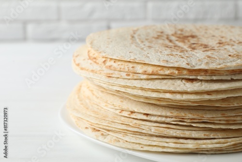 Stack of tasty homemade tortillas on white table