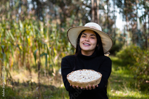 La cosecha del esfuerzo,una campesina bonita orgullosa muestra el fruto de su trabajo en la tierra, sosteniendo en su mano una canasta rebosante de maíz,estilo de vida,quechua, photo