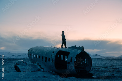 Solitary figure stands atop plane wreckage in snowy Iceland photo