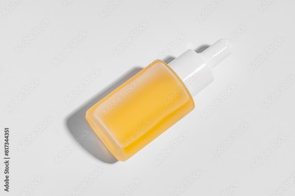 Yellow cosmetic serum in a dropper bottle on white background Yellow cosmetic serum in a dropper bottle on white background