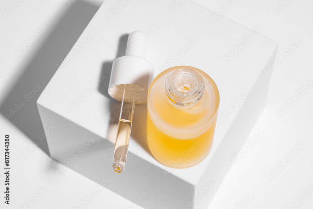 Luxury yellow serum in glass bottle on white background Luxury yellow serum in glass bottle on white background