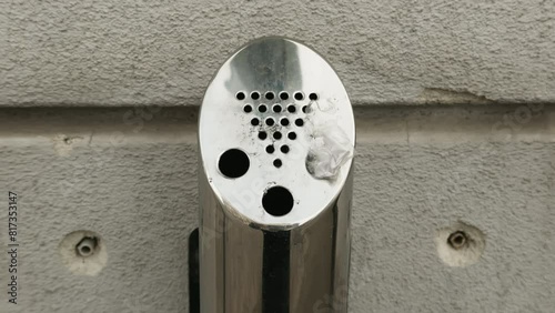 Stainless steel ashtray on building side, household hardware photo