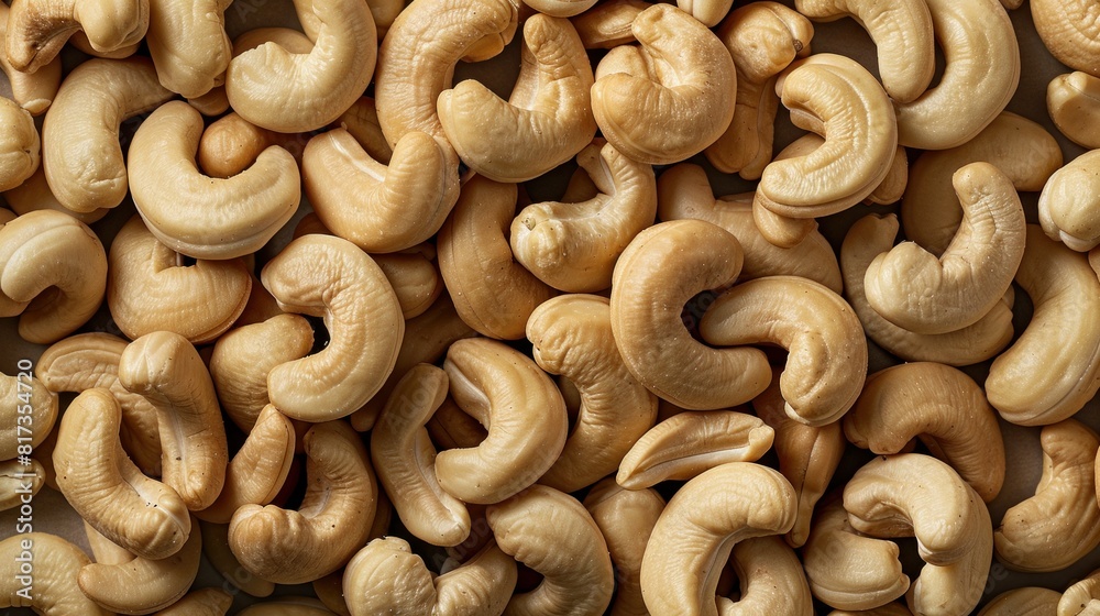 A large quantity of delicious raw cashews are arranged on a smooth tabletop in full frame top view A large quantity of delicious raw cashews are arranged on a smooth tabletop in full frame top view