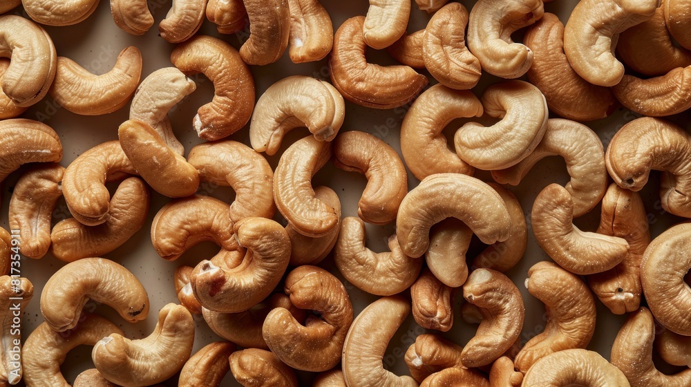 A large quantity of delicious raw cashews are arranged on a smooth tabletop in full frame top view A large quantity of delicious raw cashews are arranged on a smooth tabletop in full frame top view