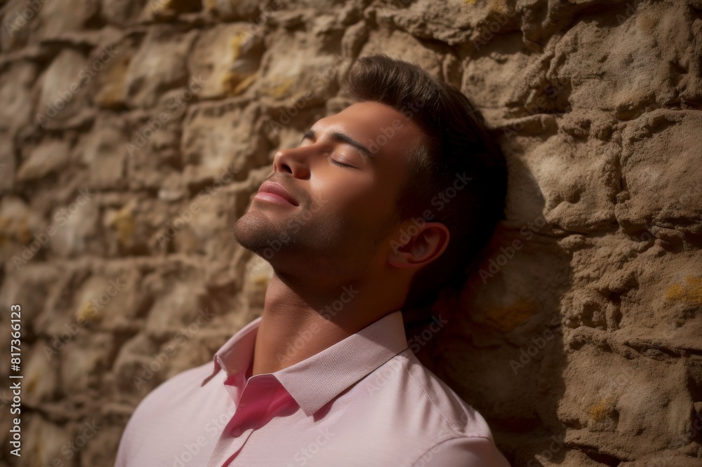 young man with eyes closed leaning on textured wall young man with eyes closed leaning on textured wall