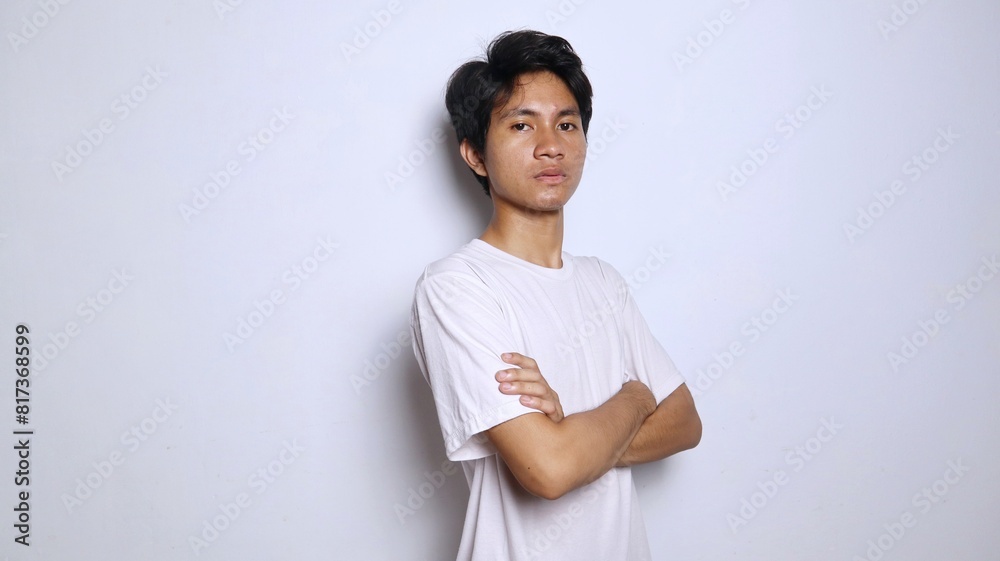 Handsome young Asian man in white shirt with crossed arms Handsome young Asian man in white shirt with crossed arms