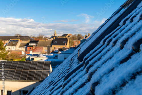 Snow on a roof with Gistel city skyline in winter, West Flanders, Belgium.