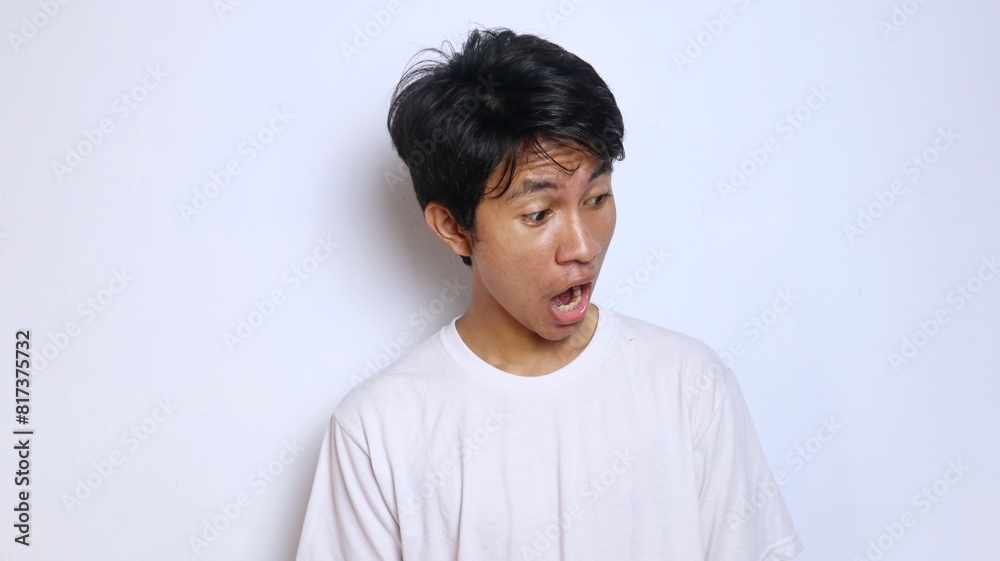 Young Asian man in white shirt with funny shocked gesture looking down Young Asian man in white shirt with funny shocked gesture looking down