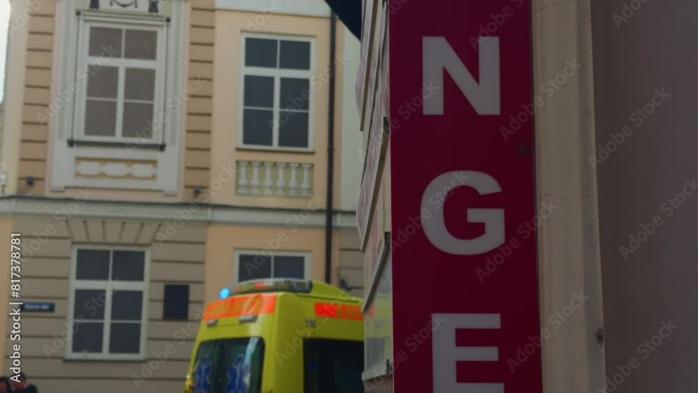 Ambulance parked by building next to emergency sign on asphalt Ambulance parked by building next to emergency sign on asphalt