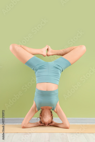 Young woman doing yoga agai...