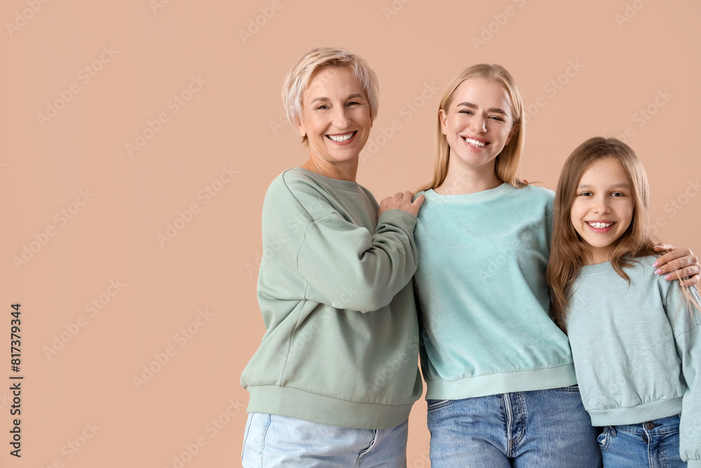 Little girl with her mom and grandmother hugging on beige background Little girl with her mom and grandmother hugging on beige background