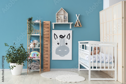 Interior of stylish children's bedroom with crib, cute animal painting and wooden stadiometer photo