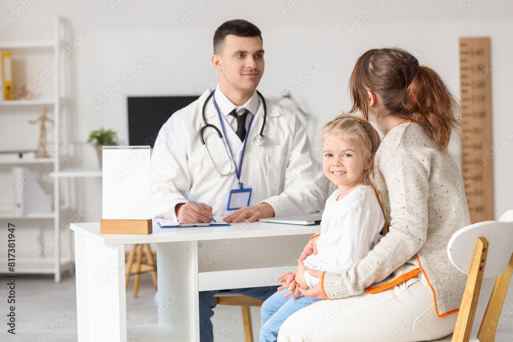 Obraz premium Mother with little girl on appointment to male pediatrician in clinic