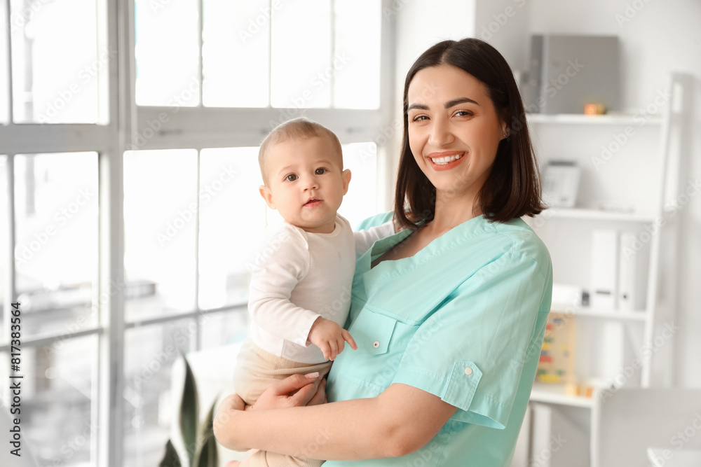 Female pediatrician holding little baby in clinic Female pediatrician holding little baby in clinic