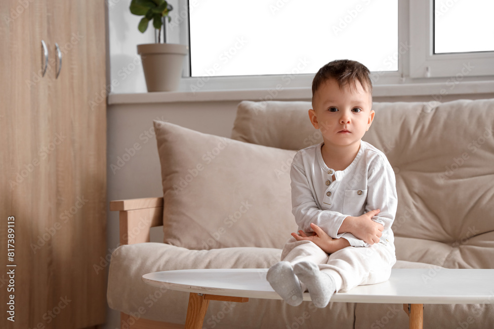 Little boy sitting on table at home. Child in danger Little boy sitting on table at home. Child in danger
