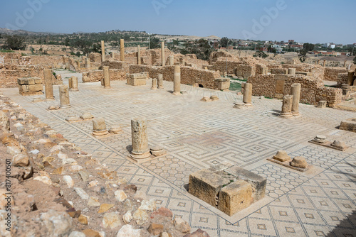 Partially reconstructed Roman Baths complex in ancient settlement of Sbeitla in Tunisia with well preserved mosaic floor and remnants of stone columns on sunny day photo