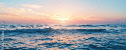 Calm ocean waves at sunset with a clear sky above. The serene water reflects the soft pastel hues of the setting sun, creating a peaceful and tranquil seascape. © Dalibor