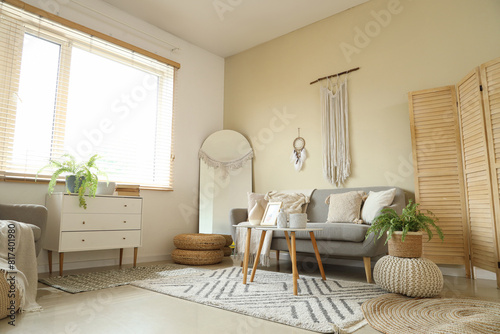 Interior of cozy living room with sofa, dream catcher and wall tapestry